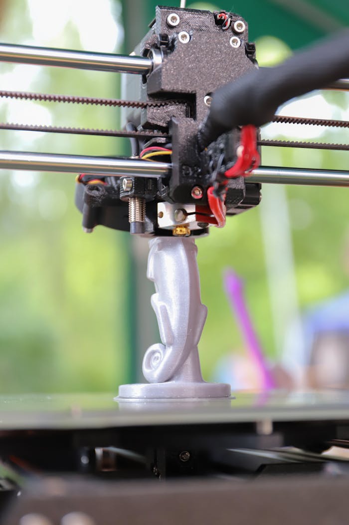 The Art of Drawing Readers In: Your attractive post title goes here Close-up of a 3D printer creating a decorative figurine, showcasing modern technology in action.